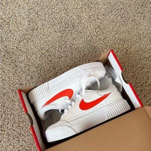 Nike White Platform Sneakers with Bright Orange Swoosh.